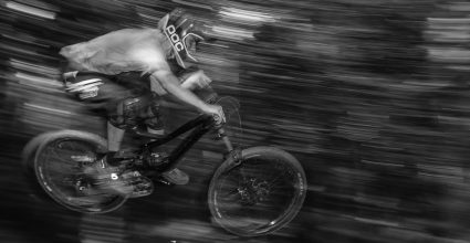 A Person riding a mountain bike down hill with blurred back ground