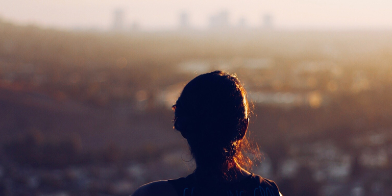 Silhouette of some one looking toward a city at day break 